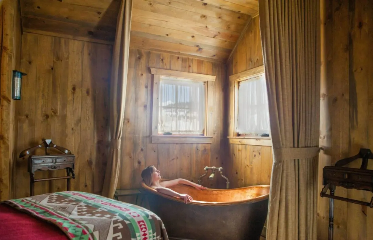 Guest in copper bathtub at Devil's Thumb Ranch